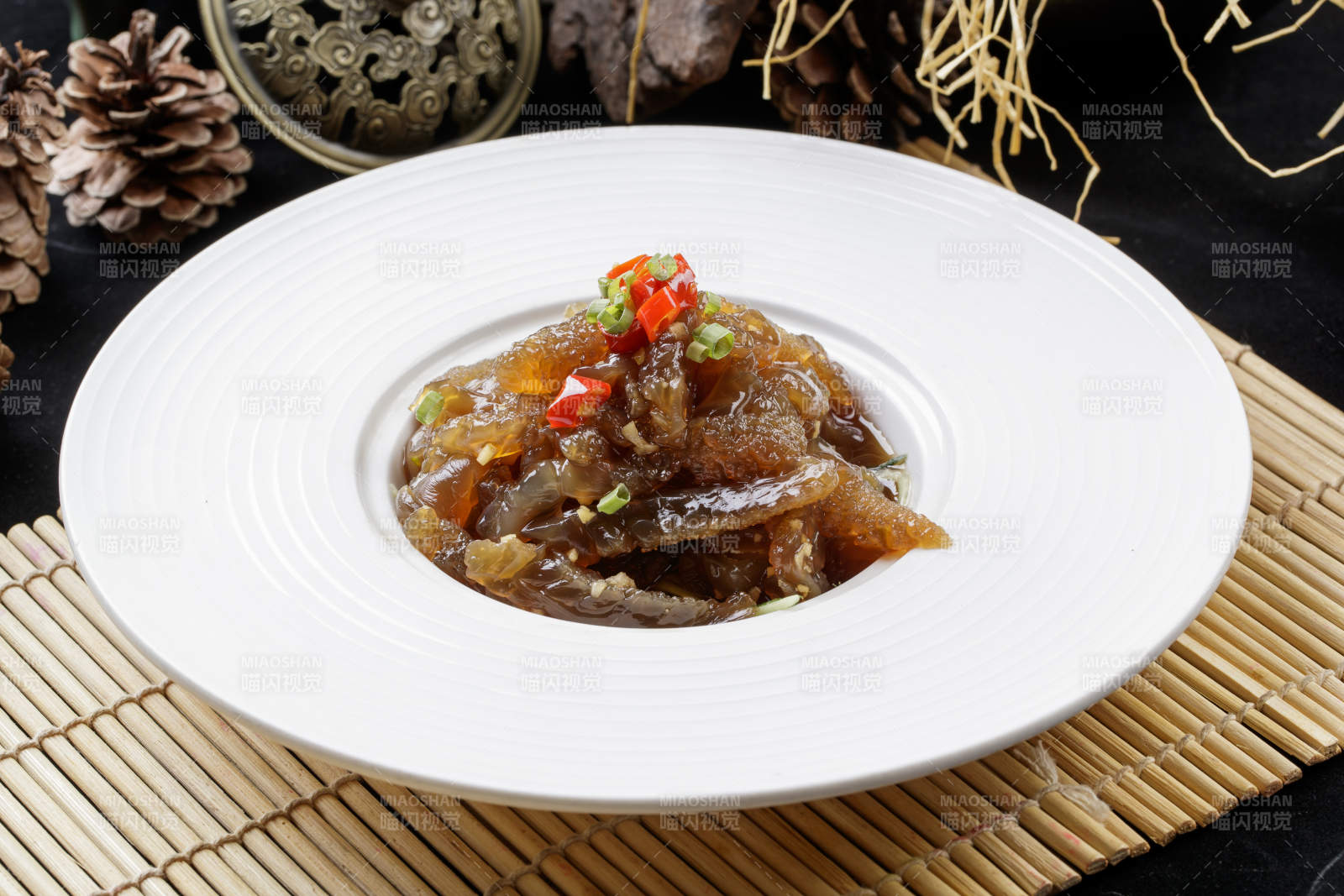 寿司帘上的圆瓷盘装的老醋蛰头图片