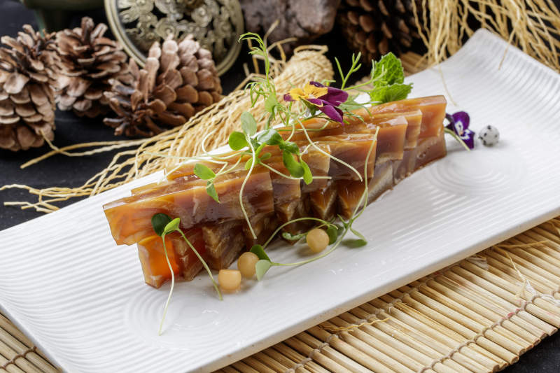 寿司帘上的长瓷盘装的美味猪皮冻图片