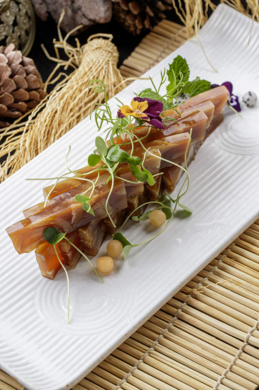 寿司帘上的长瓷盘装的美味猪皮冻图片