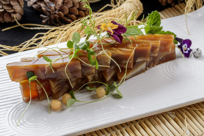 寿司帘上的长瓷盘装的美味猪皮冻图片