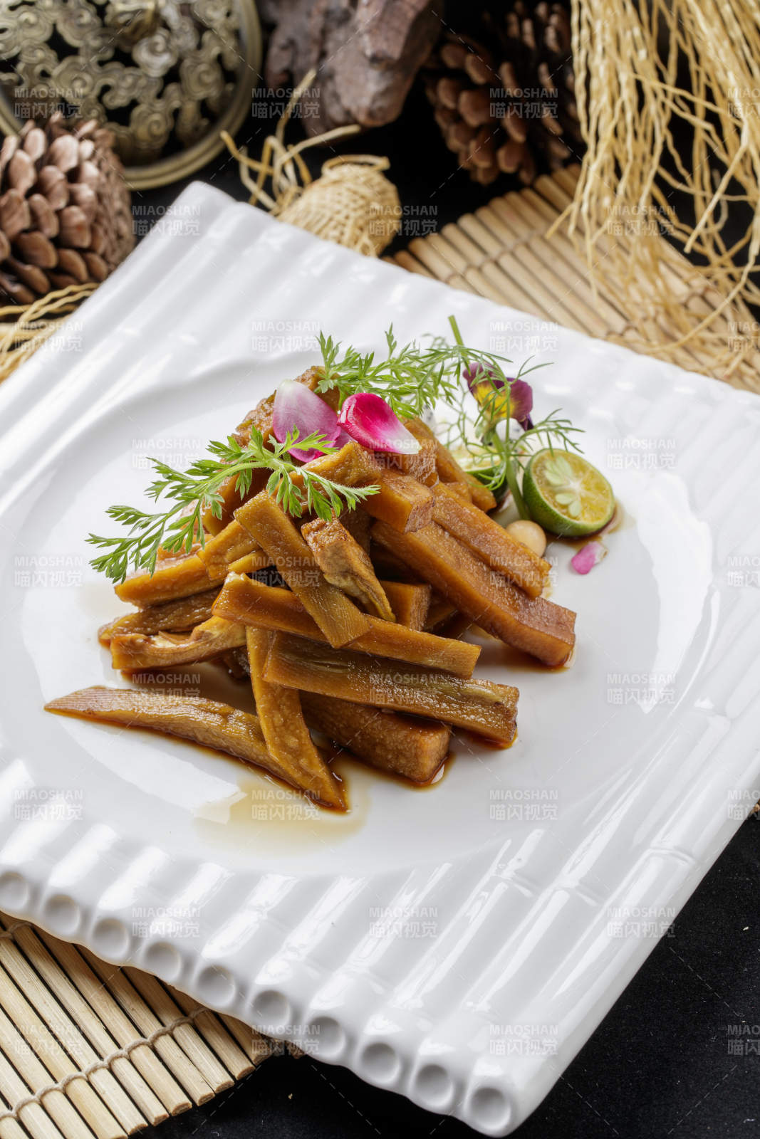 寿司帘上的方瓷盘装的暴腌萝卜条图片