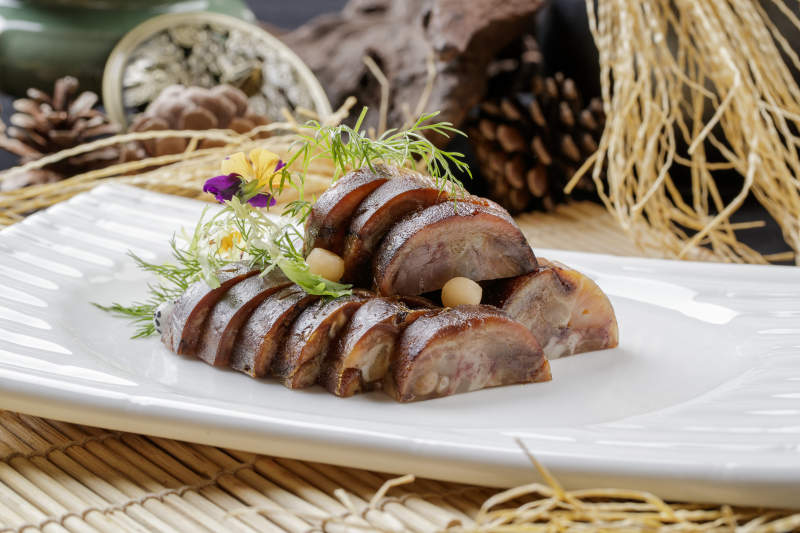 寿司帘上的长瓷盘装的熏肘花图片