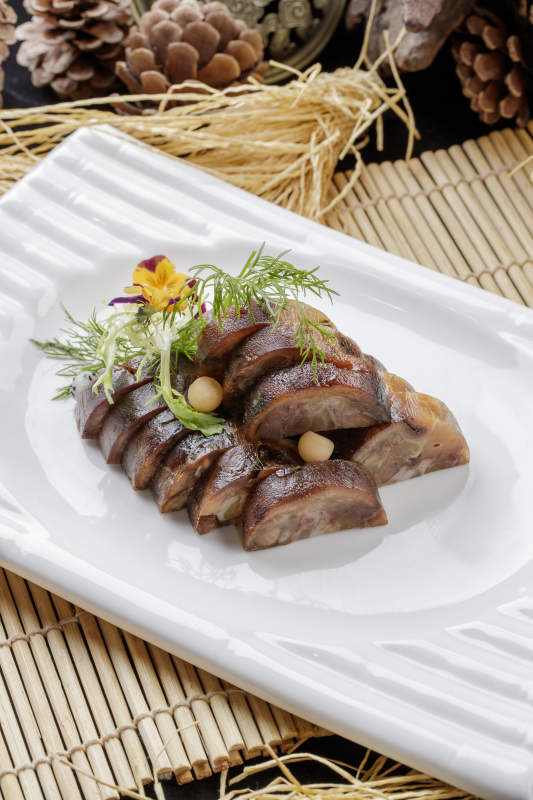 寿司帘上的长瓷盘装的熏肘花图片