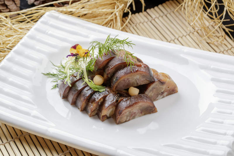 寿司帘上的长瓷盘装的熏肘花图片