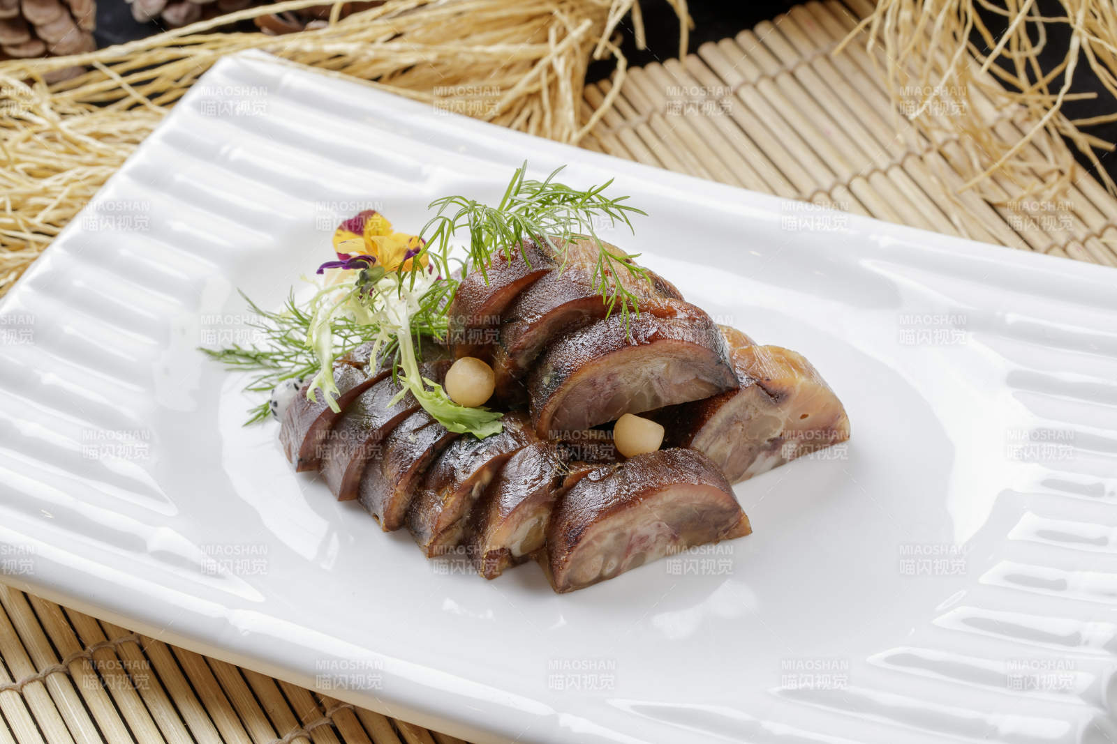 寿司帘上的长瓷盘装的熏肘花图片