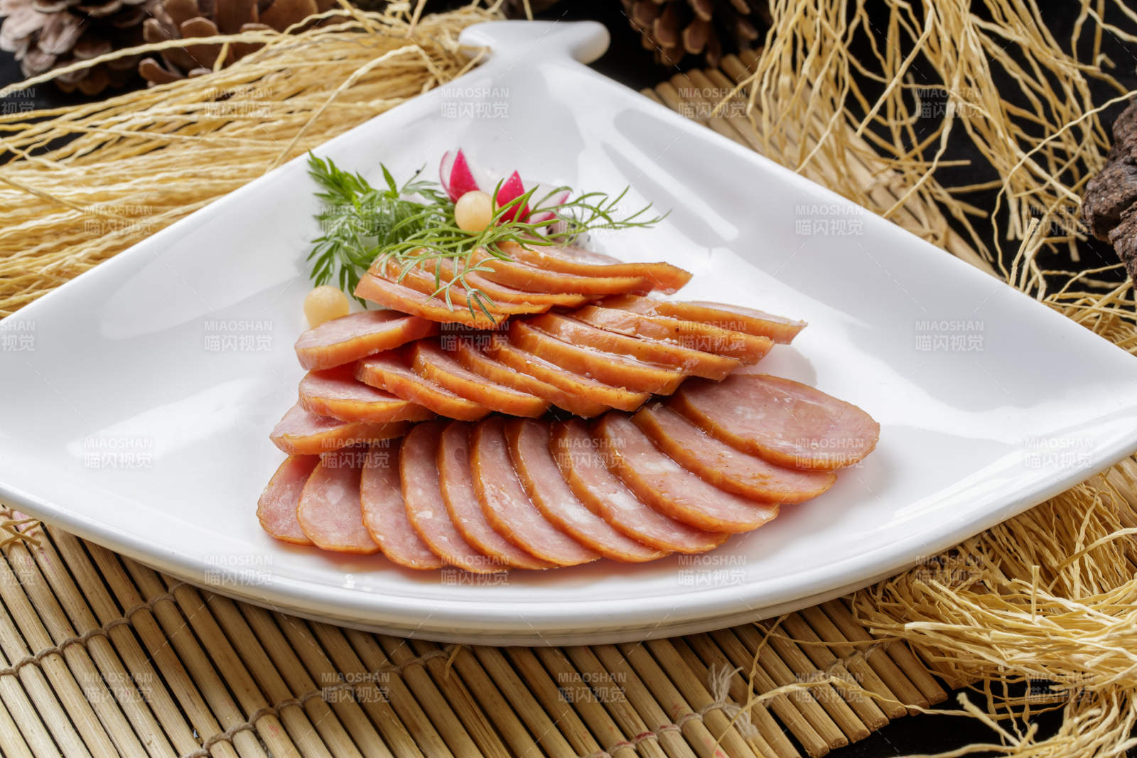 寿司帘上的扇形瓷盘装的自制蒜味香肠图片