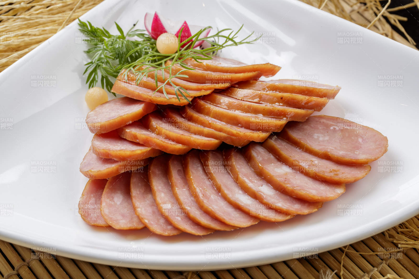 寿司帘上的扇形瓷盘装的自制蒜味香肠图片