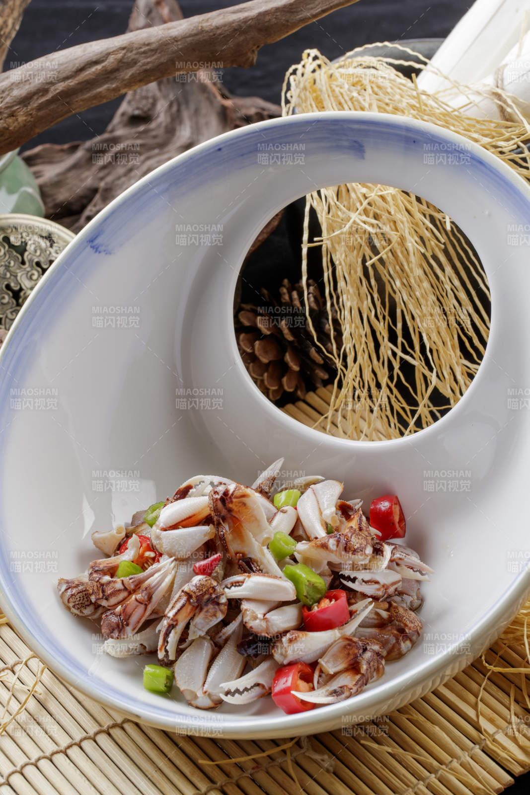 寿司帘上的异形瓷盘装的糟醉蟹钳图片