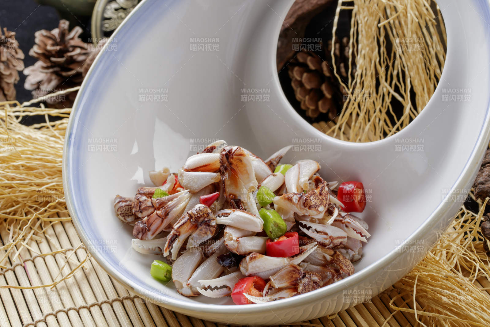 寿司帘上的异形瓷盘装的糟醉蟹钳图片