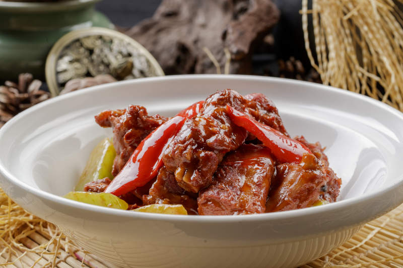 寿司帘上的白色砂锅装的酱小排图片