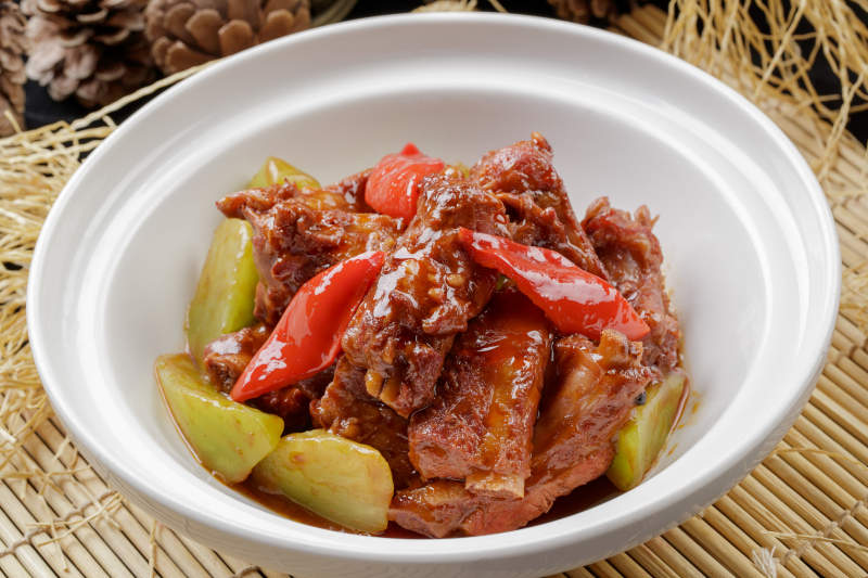 寿司帘上的白色砂锅装的酱小排图片