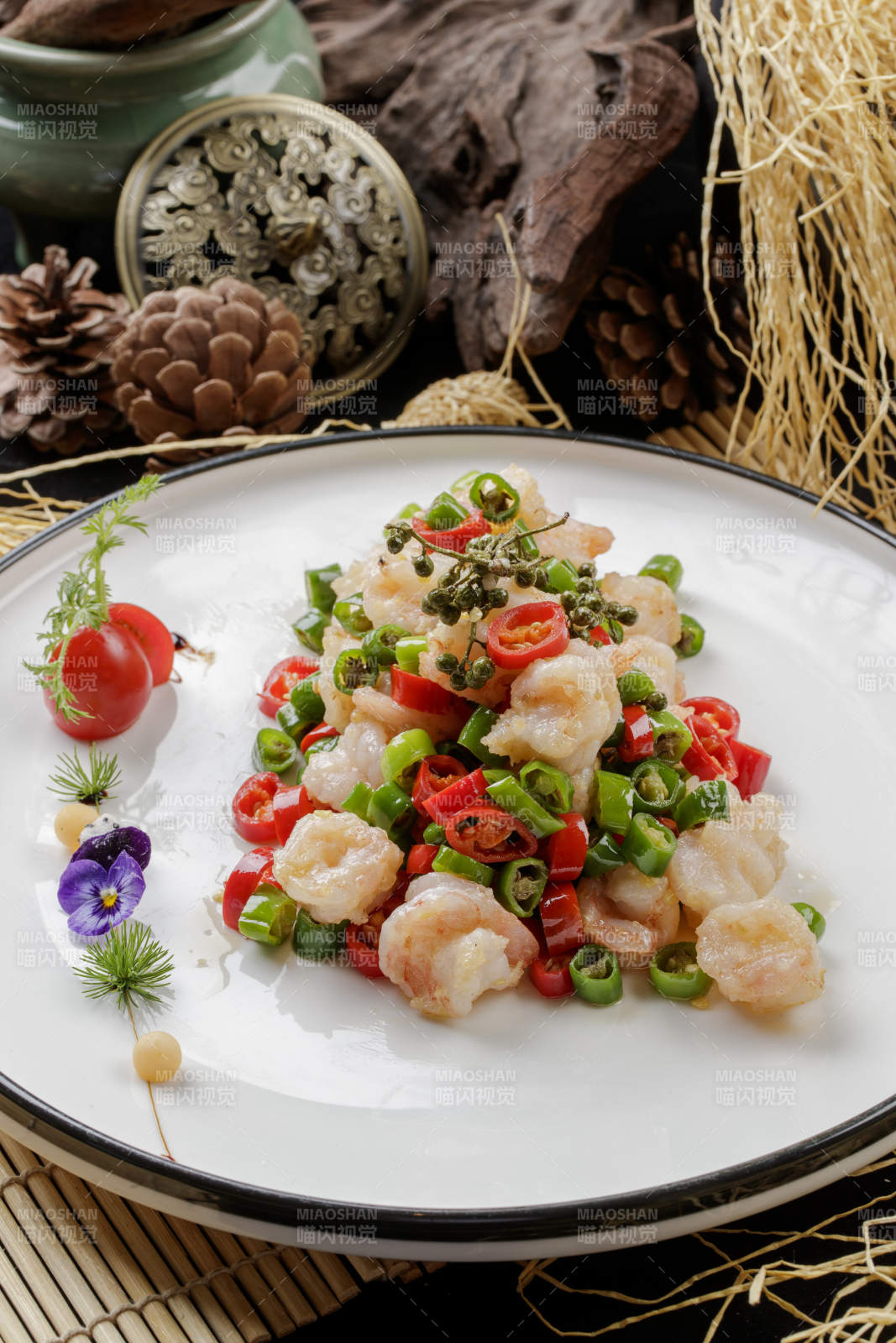 寿司帘上的白色圆盘装的米椒虾仁图片