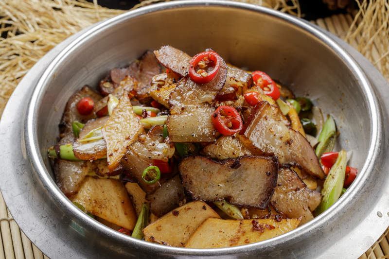 不锈钢餐具装的干锅腊肉土豆片图片