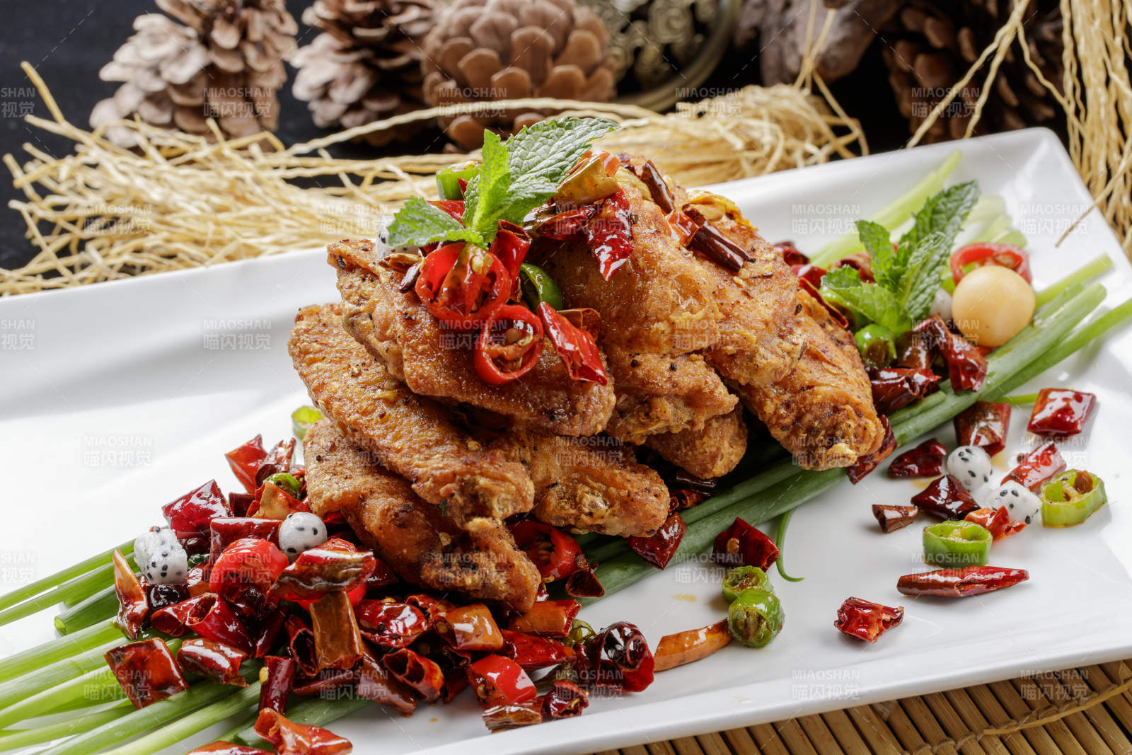 白色瓷盘装的香辣干炸鸡翅中图片