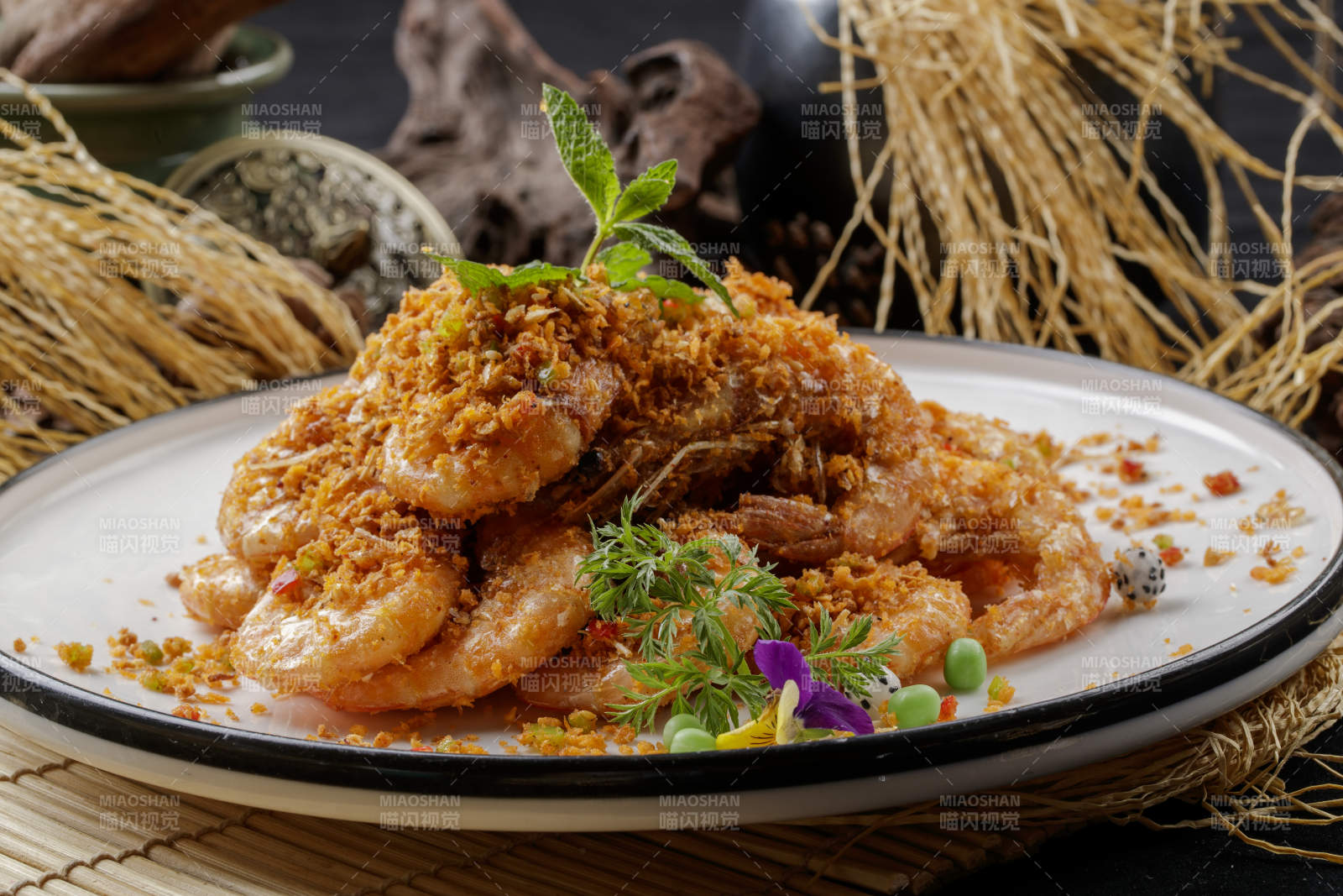 寿司帘上的圆瓷盘装的酥炸大明虾图片