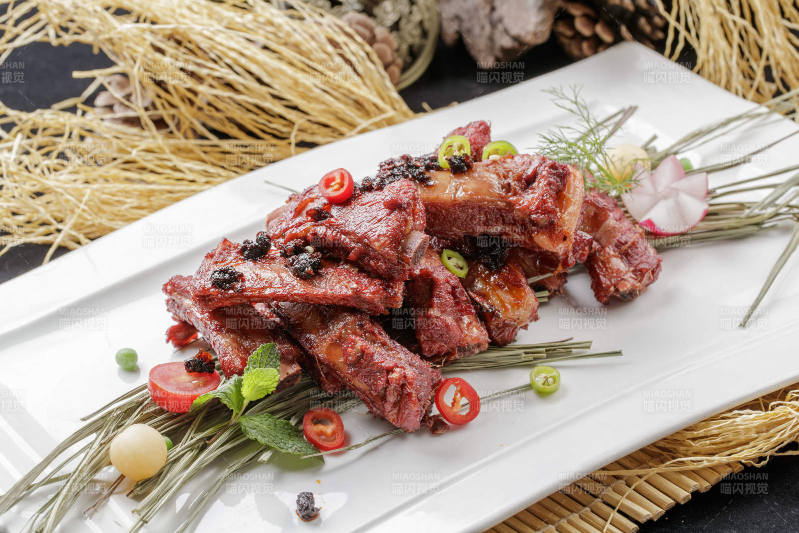 寿司帘上的长瓷盘装的豆豉酱小排图片