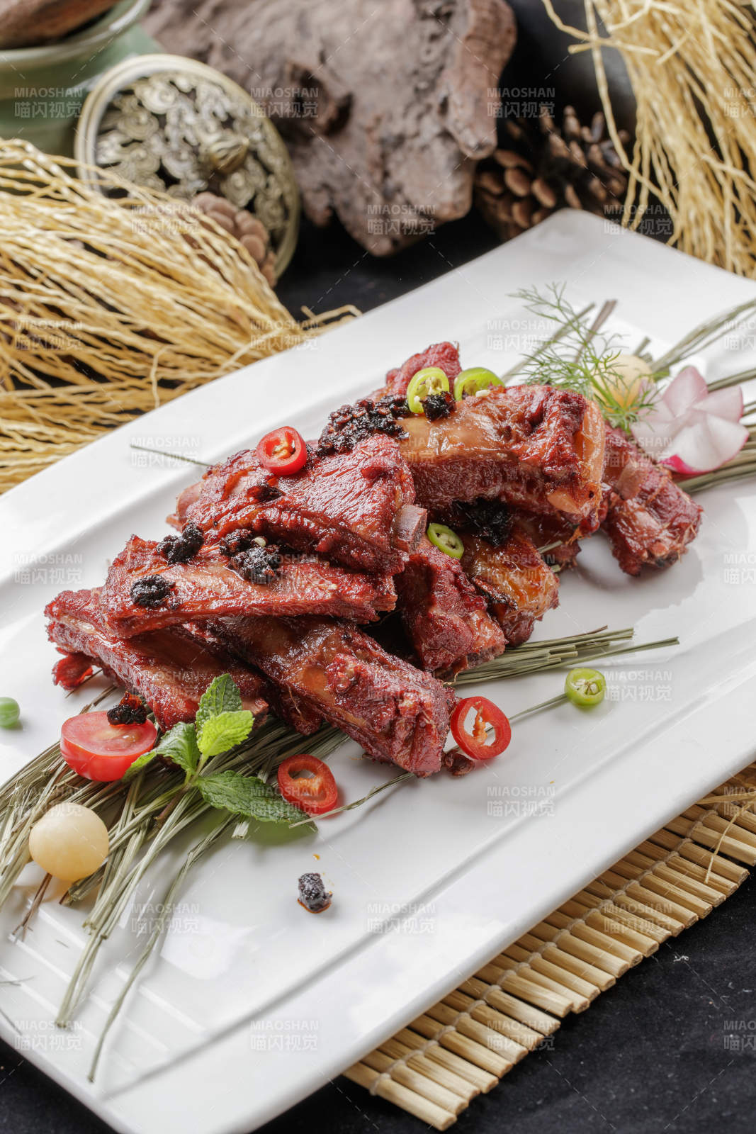 寿司帘上的长瓷盘装的豆豉酱小排图片