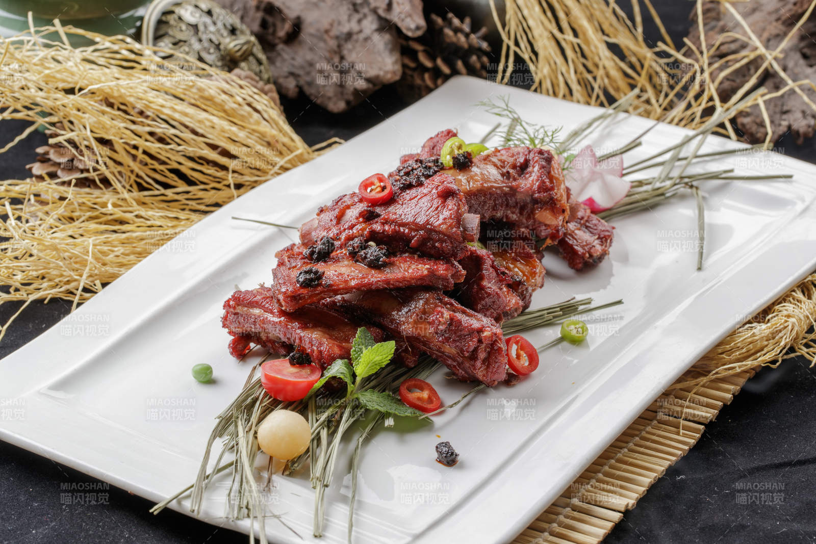 寿司帘上的长瓷盘装的豆豉酱小排图片