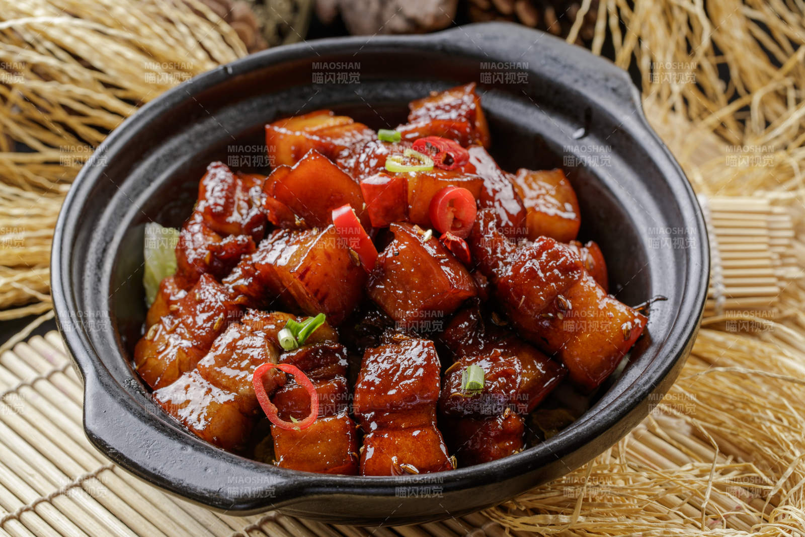 寿司帘上的黑色砂锅装的毛氏红烧肉图片