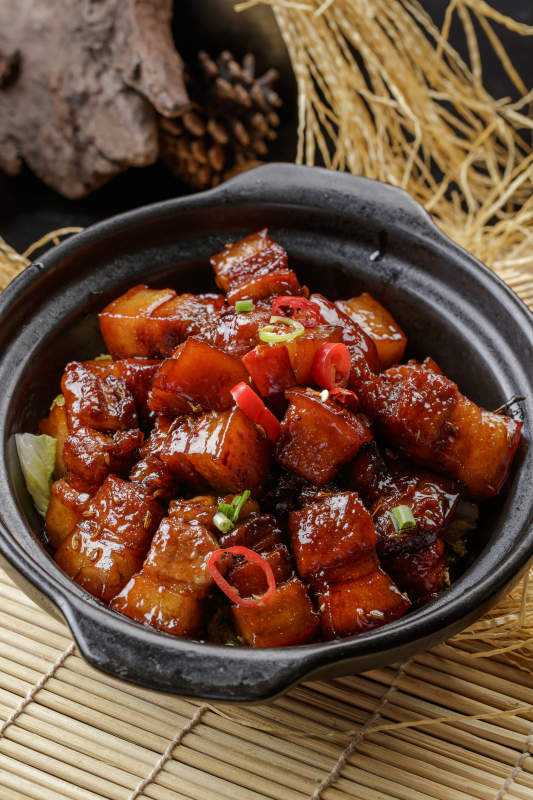 寿司帘上的黑色砂锅装的毛氏红烧肉图片