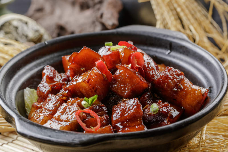 寿司帘上的黑色砂锅装的毛氏红烧肉图片