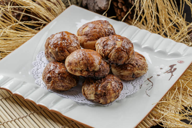 寿司帘上的方瓷盘装的红糖麻酱饼图片