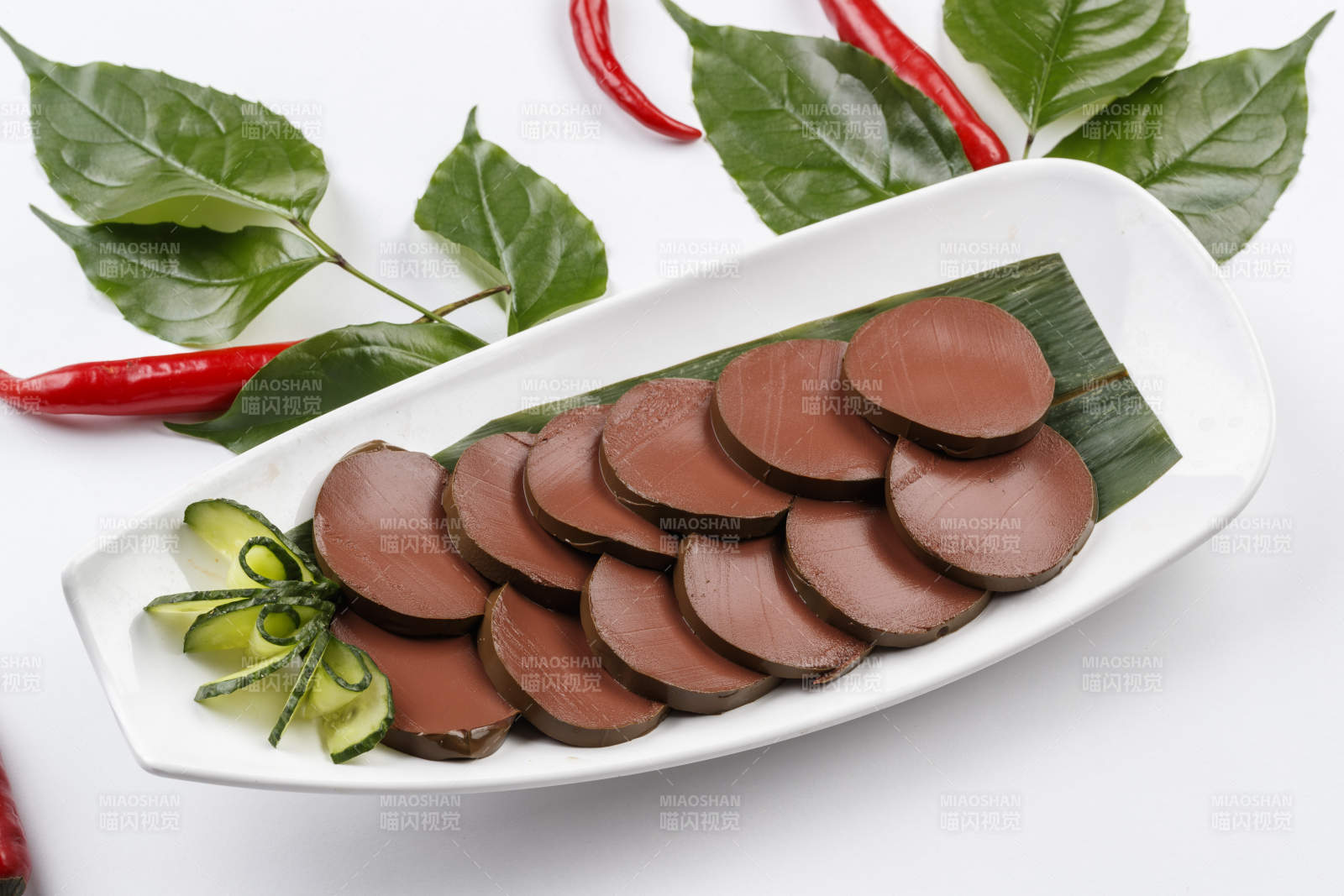 白色背景上的长瓷盘装的火锅食材鸭血图片