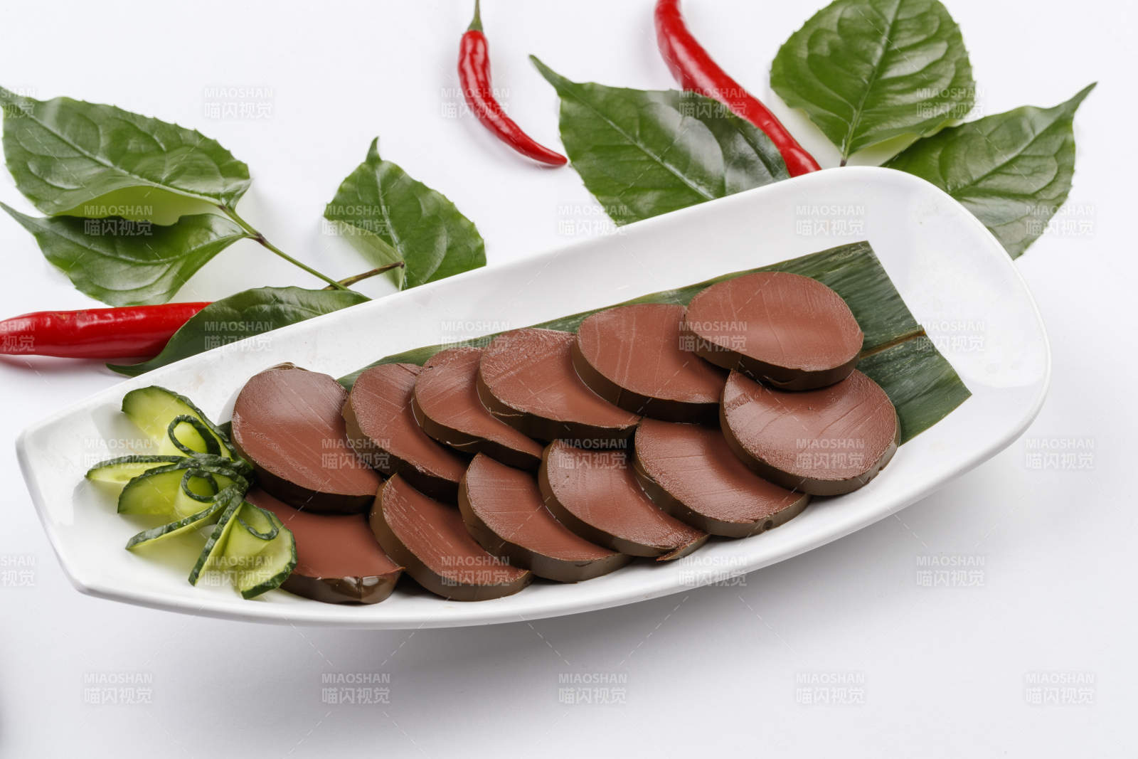 白色背景上的长瓷盘装的火锅食材鸭血图片