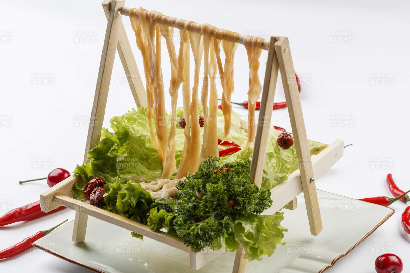 白色背景上的木架挂着的火锅食材新鲜鸭肠图片