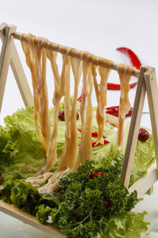 白色背景上的木架挂着的火锅食材新鲜鸭肠图片