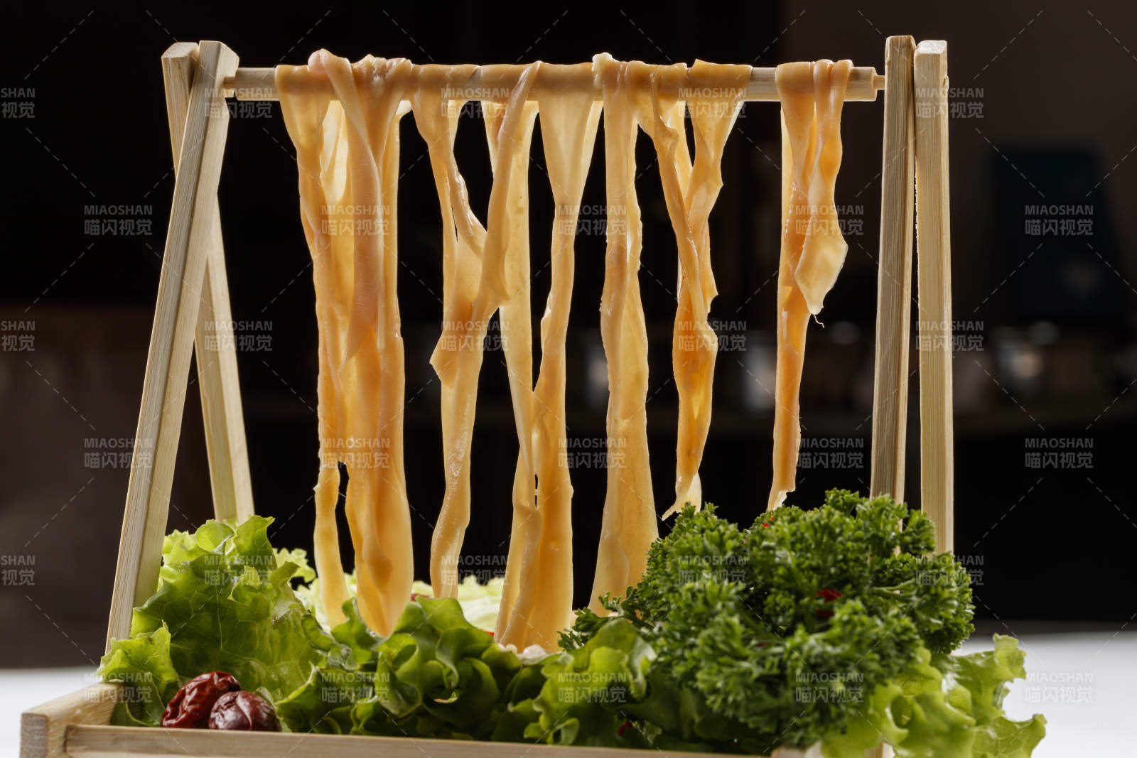 白色背景上的木架挂着的火锅食材新鲜鸭肠图片