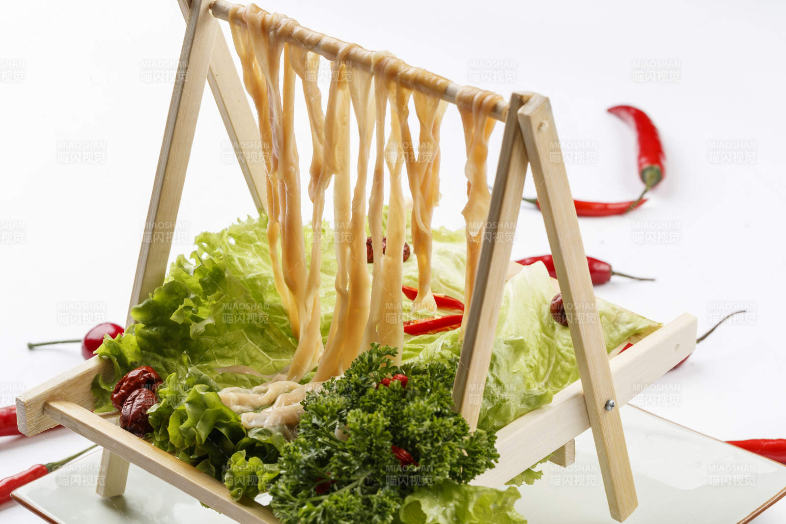 白色背景上的木架挂着的火锅食材新鲜鸭肠图片