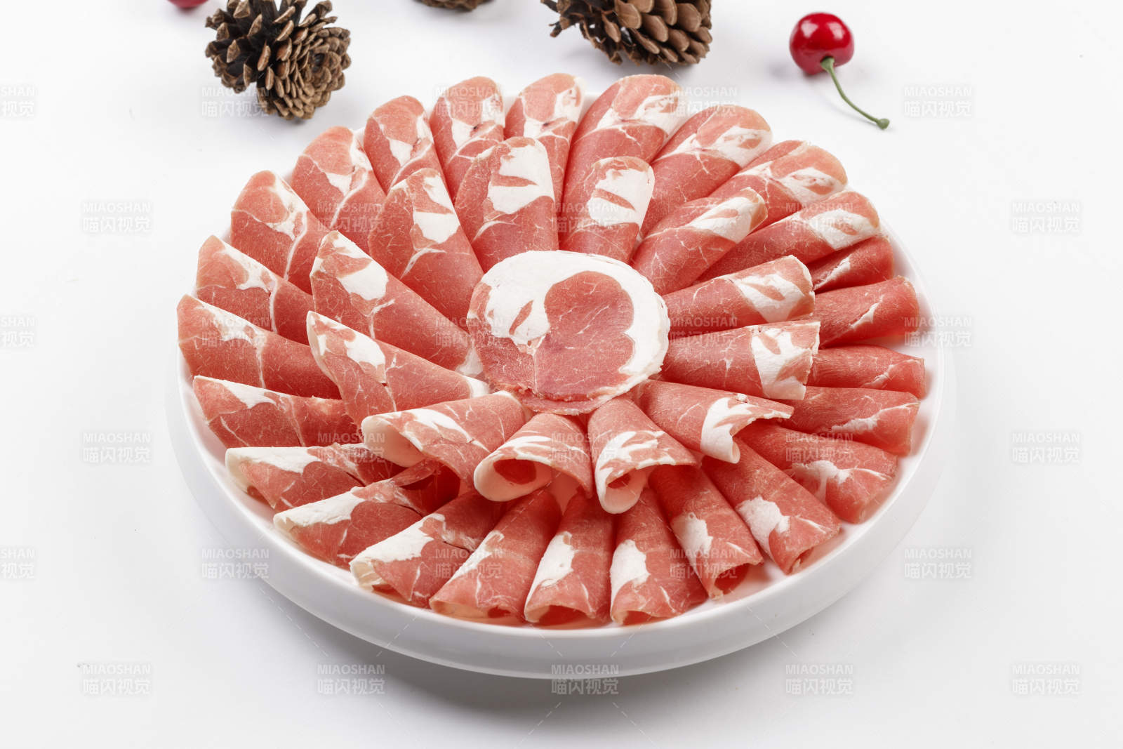 白色背景上的圆瓷盘装的涮锅食材肥牛片图片