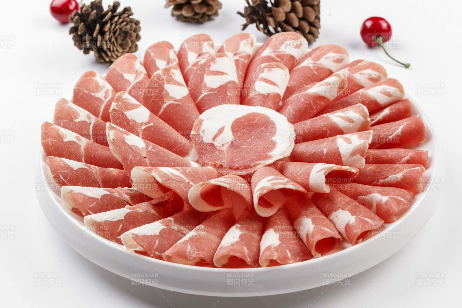 白色背景上的圆瓷盘装的涮锅食材肥牛片图片
