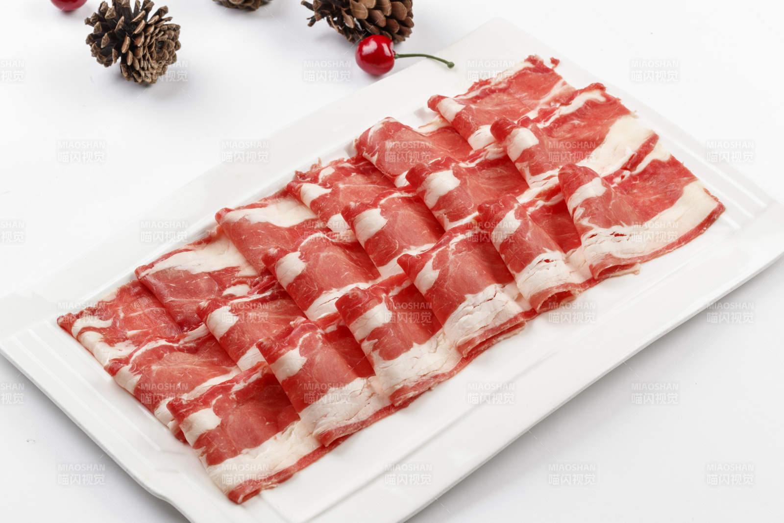 白色背景上的长瓷盘装的涮肉食材羊肉片图片