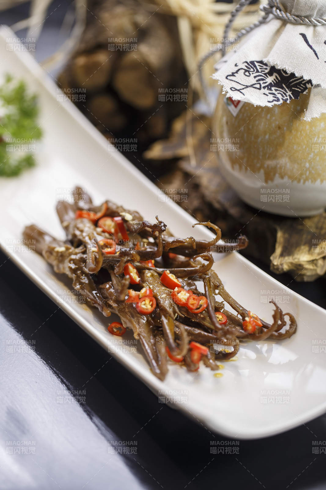 月牙形瓷盘装的川味鸭舌图片