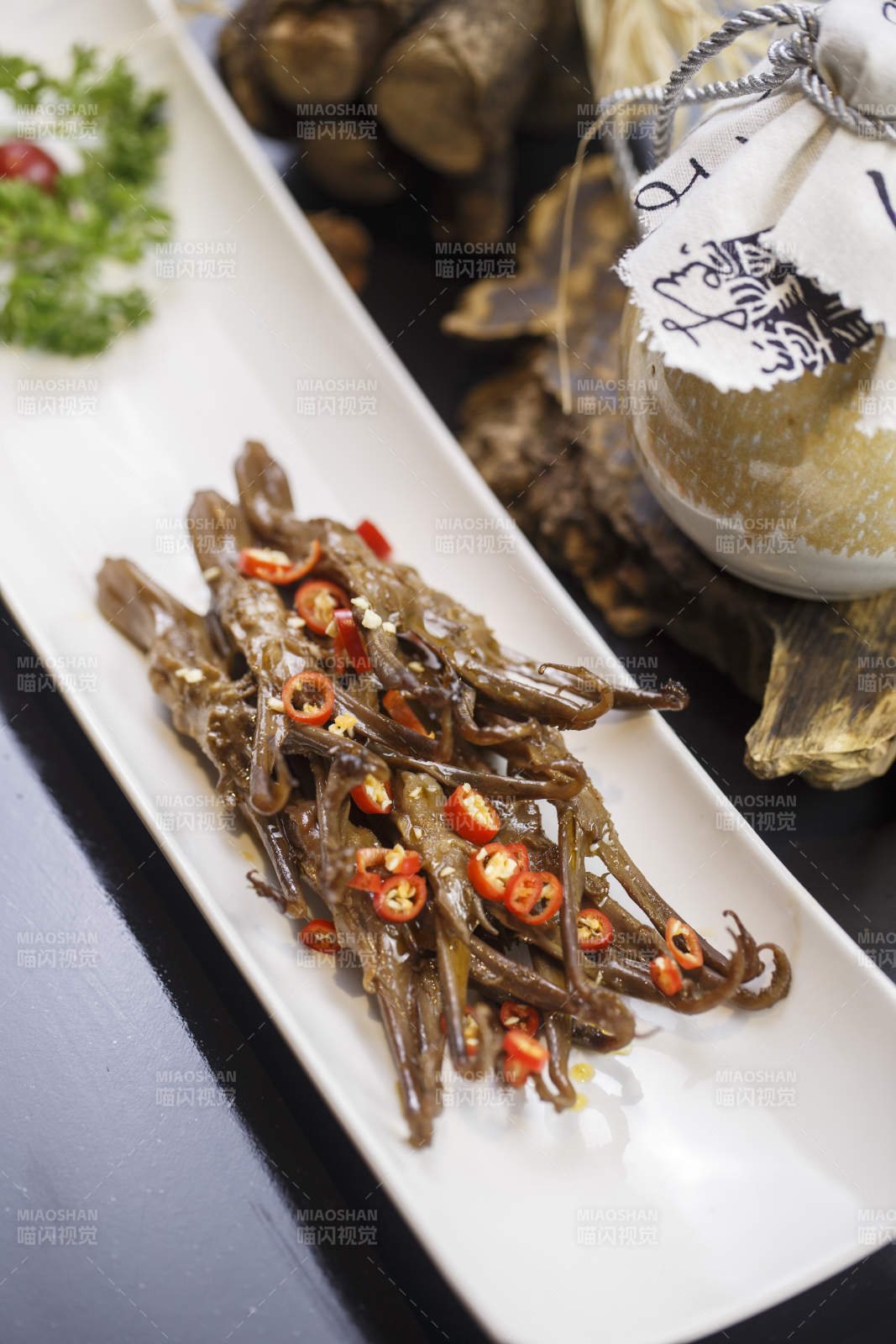 月牙形瓷盘装的川味鸭舌图片