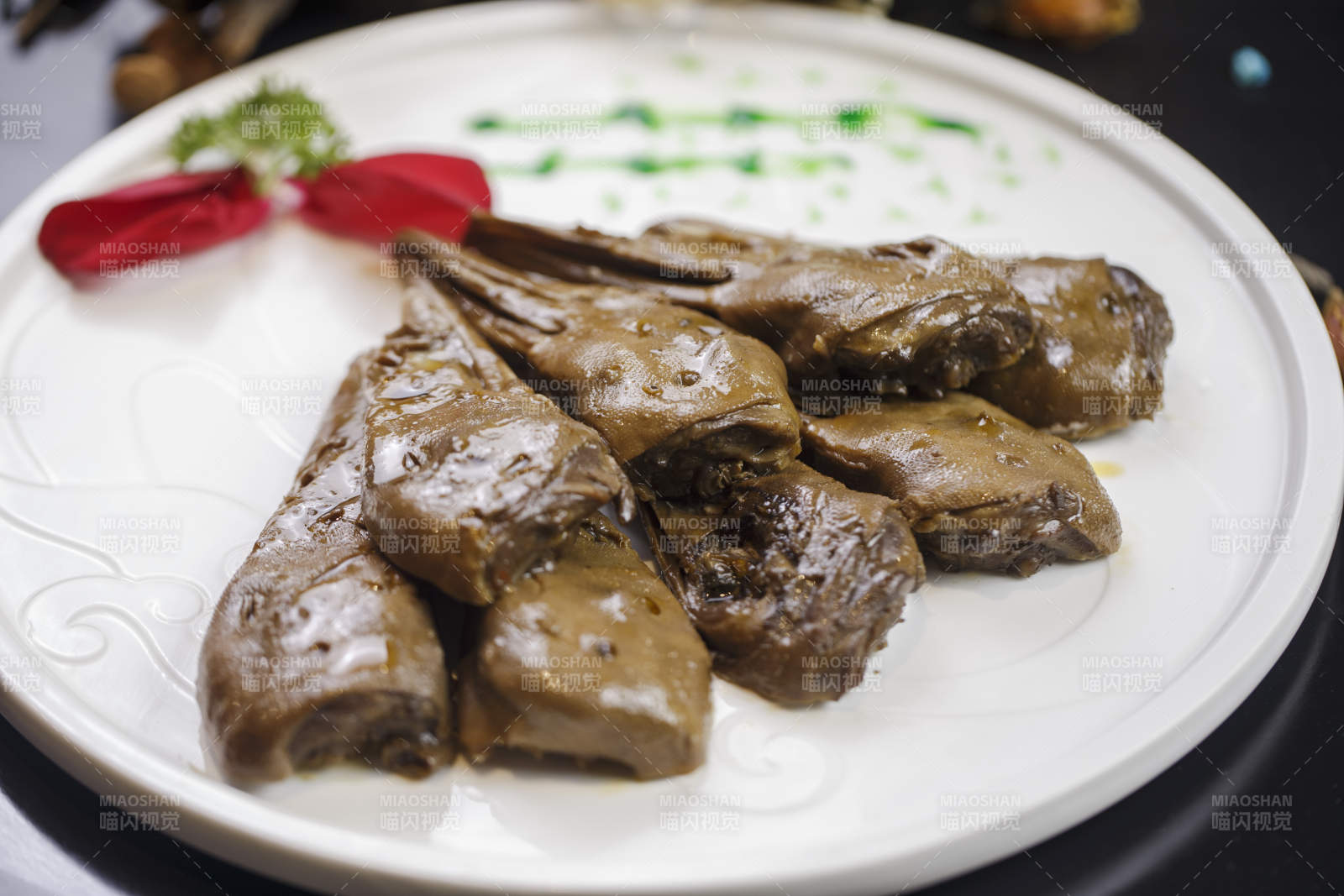 圆形瓷盘装的辣卤鸭头图片