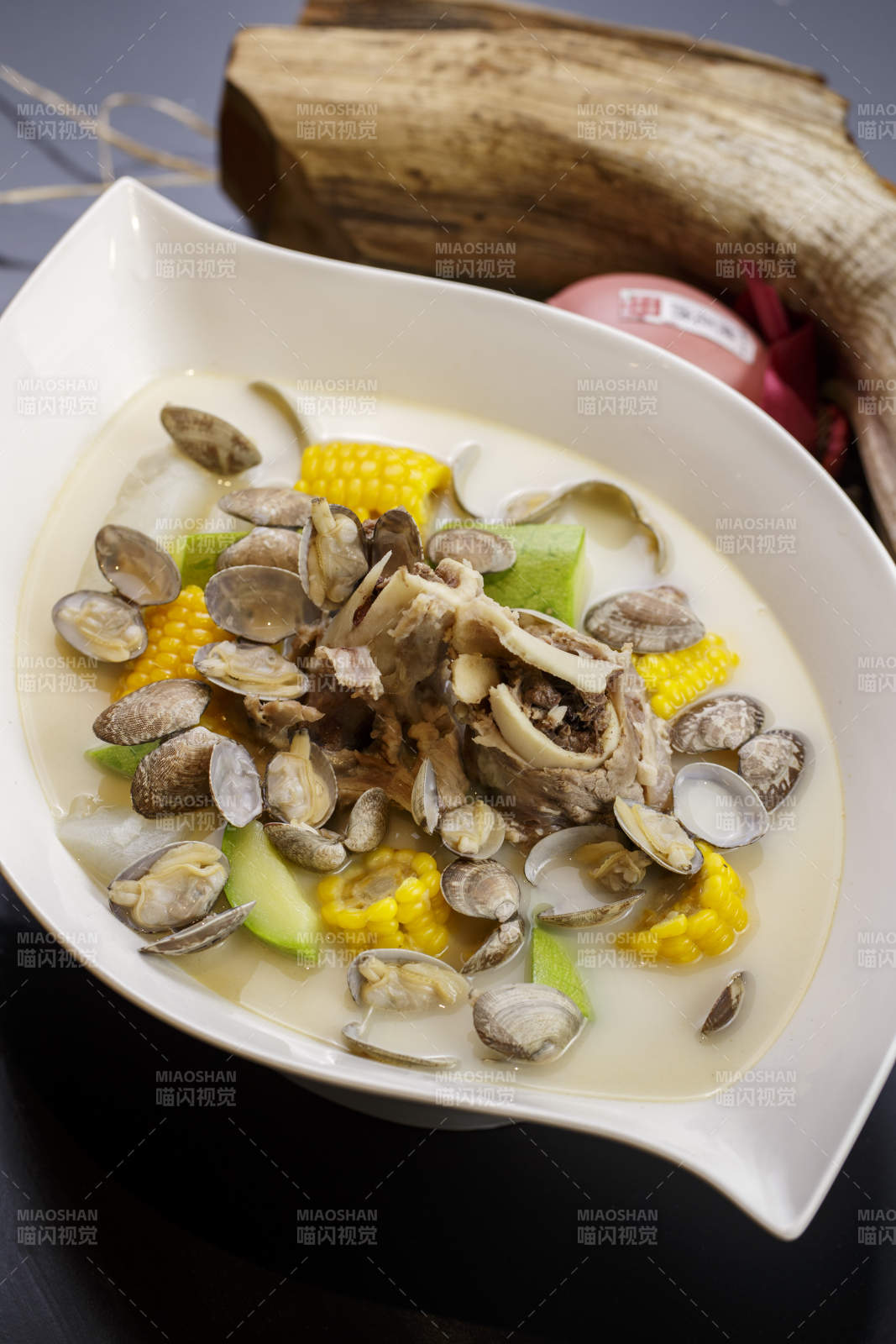 树叶形瓷盘装的奶汤棒骨花蛤炖时蔬图片