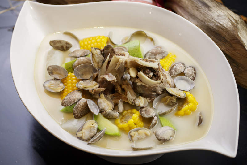 树叶形瓷盘装的奶汤棒骨花蛤炖时蔬图片