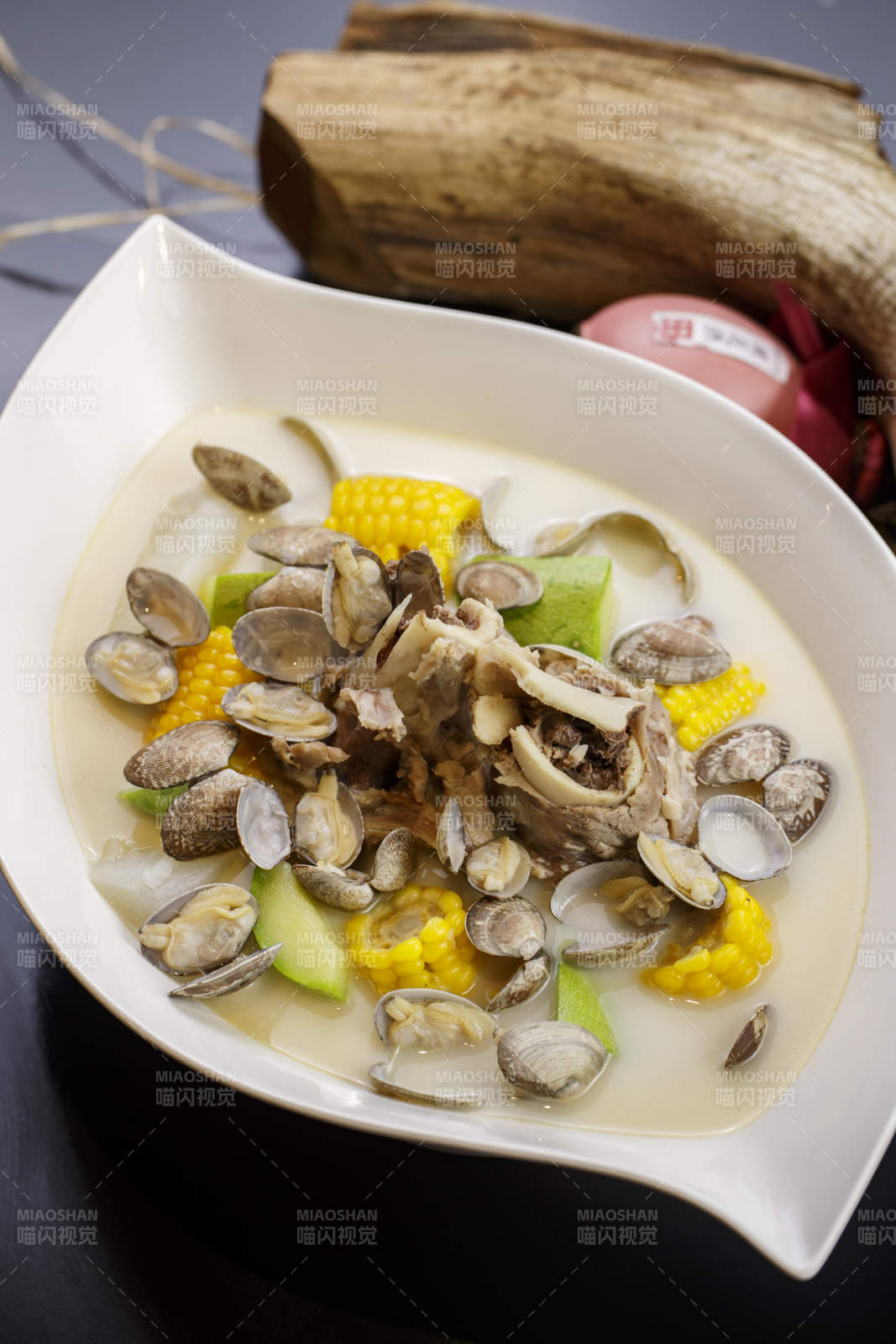 树叶形瓷盘装的奶汤棒骨花蛤炖时蔬图片