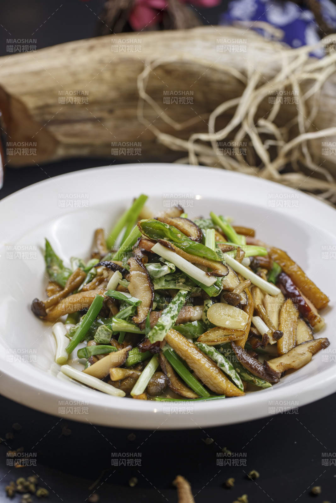 圆形白色瓷盘装的腊肉小炒山珍菌图片