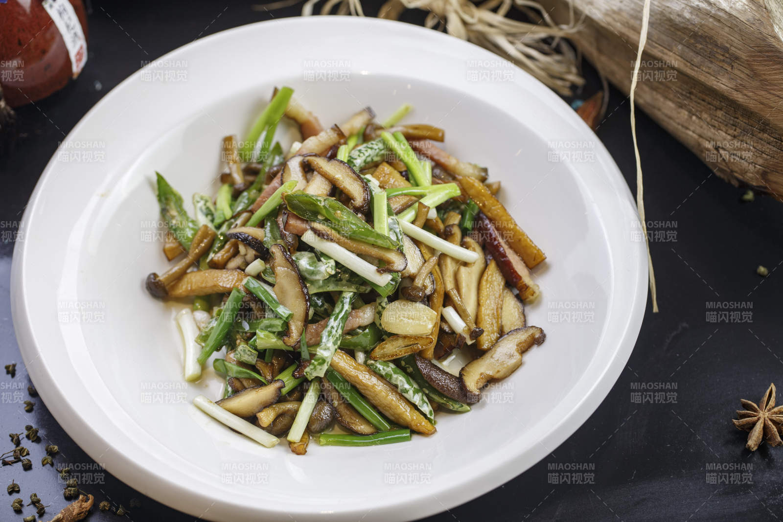 圆形白色瓷盘装的腊肉小炒山珍菌图片