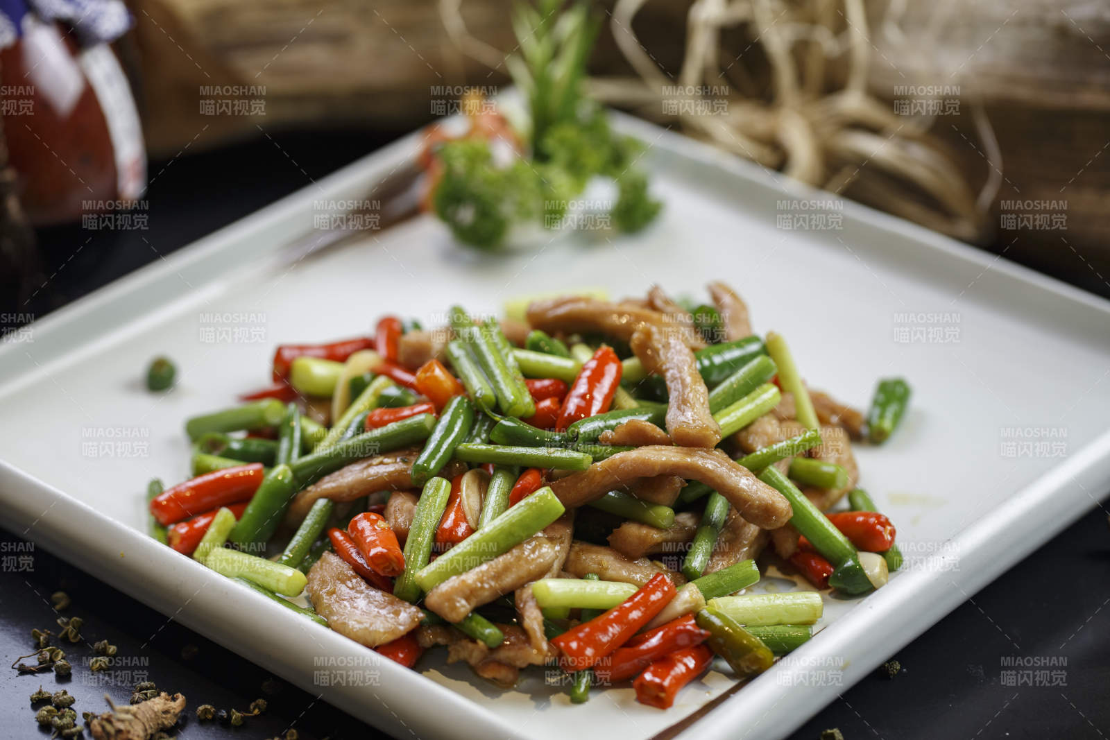 方形白瓷盘装的香辣蒜薹小炒肉图片