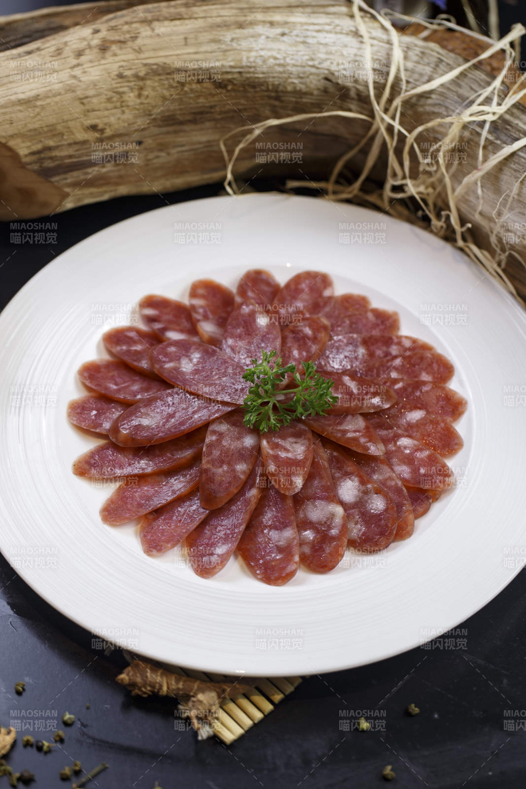 圆形白瓷盘装的川味甜腊肠图片
