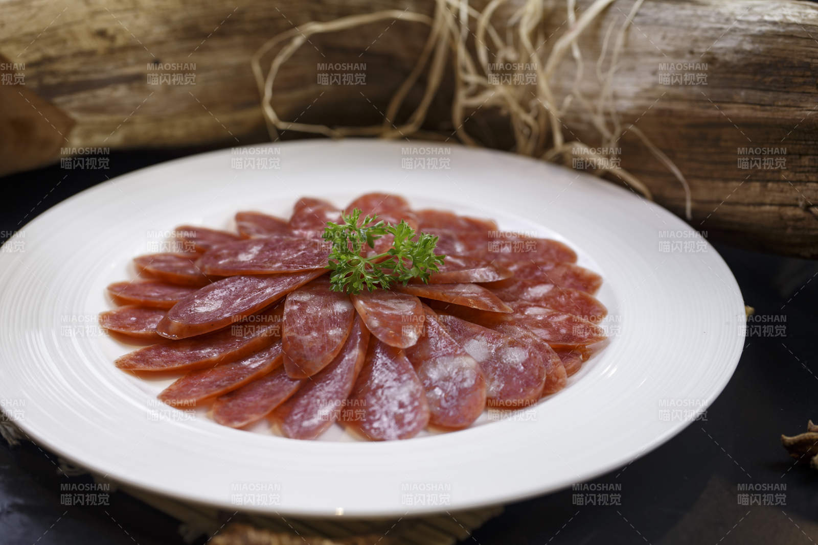 圆形白瓷盘装的川味甜腊肠图片