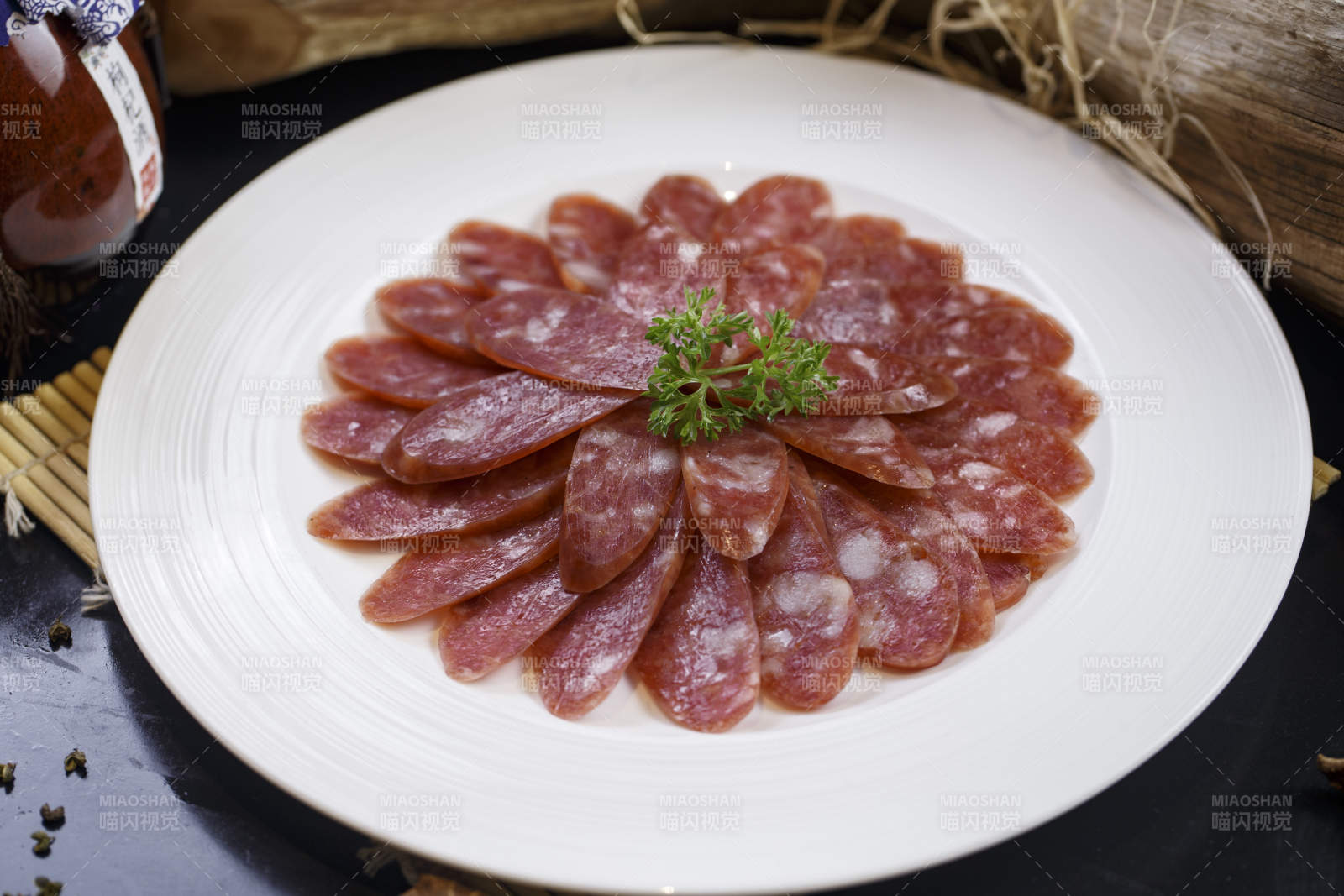 圆形白瓷盘装的川味甜腊肠图片