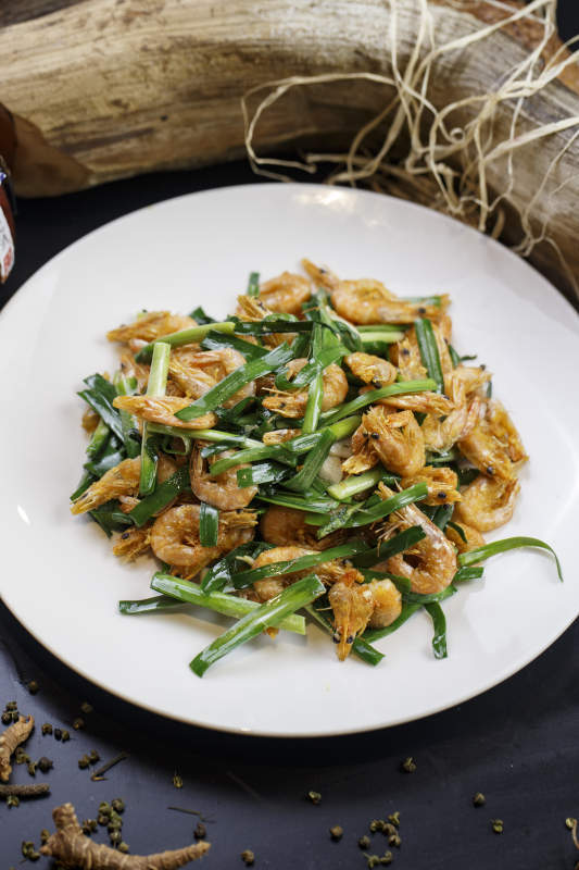 圆形白瓷盘装的韭菜炝炒小河虾图片