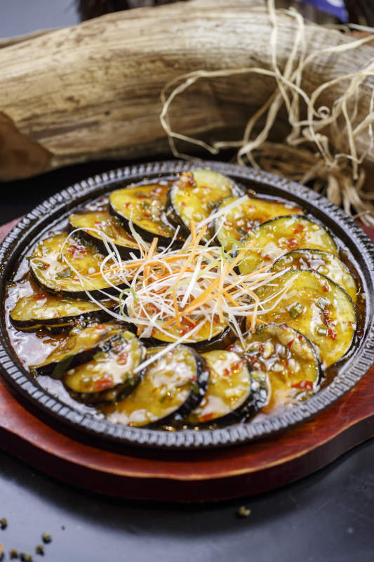 木质托盘上的铁盘装的铁板鱼香茄盒图片