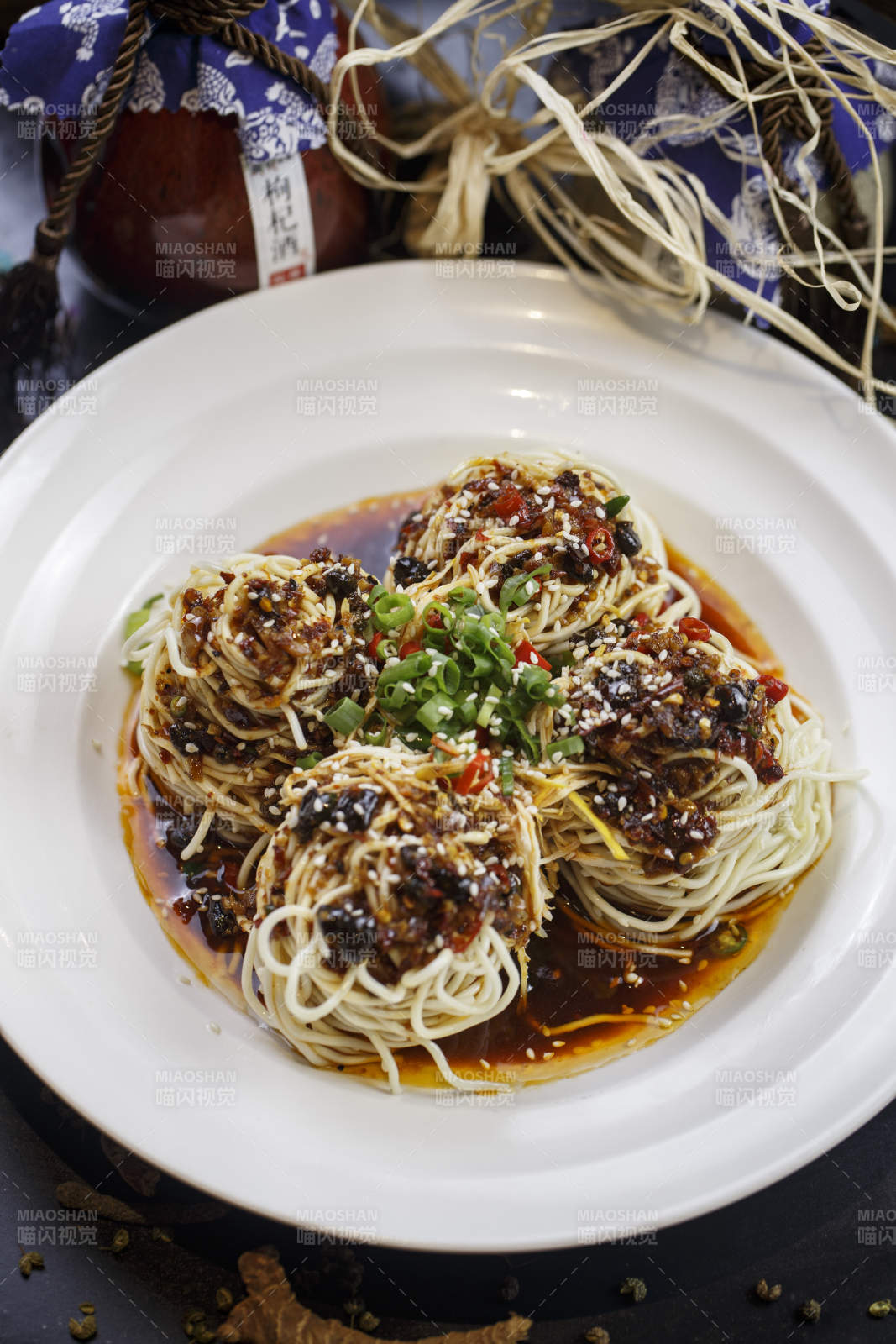 圆形白瓷盘装的麻辣鸡丝担担面图片